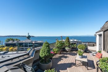 A balcony with a table and chairs overlooking a body of water.